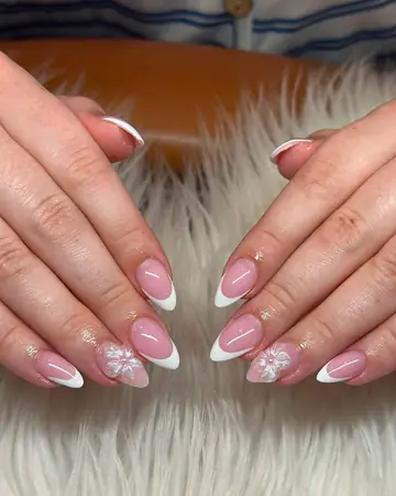 Soft pink almond nails with white French tips and snowflake accents