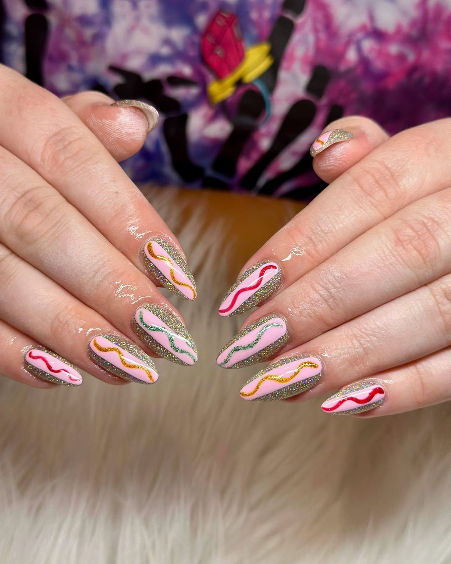 Nude almond nails with orange and green wavy swirl lines