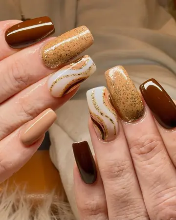 Chocolate brown and gold glitter square nails with a white marble swirl accent