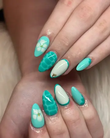 Teal almond nails with white hibiscus, sea turtle shell and gold charm accents